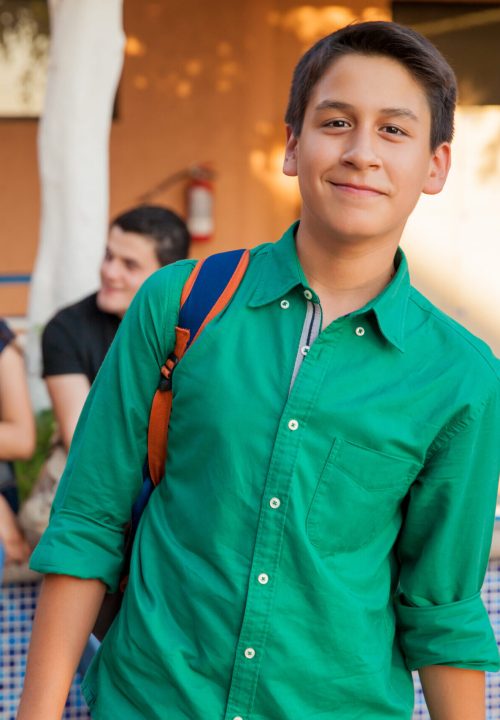 Portrait of an attractive teenage boy and his friends hanging out at school